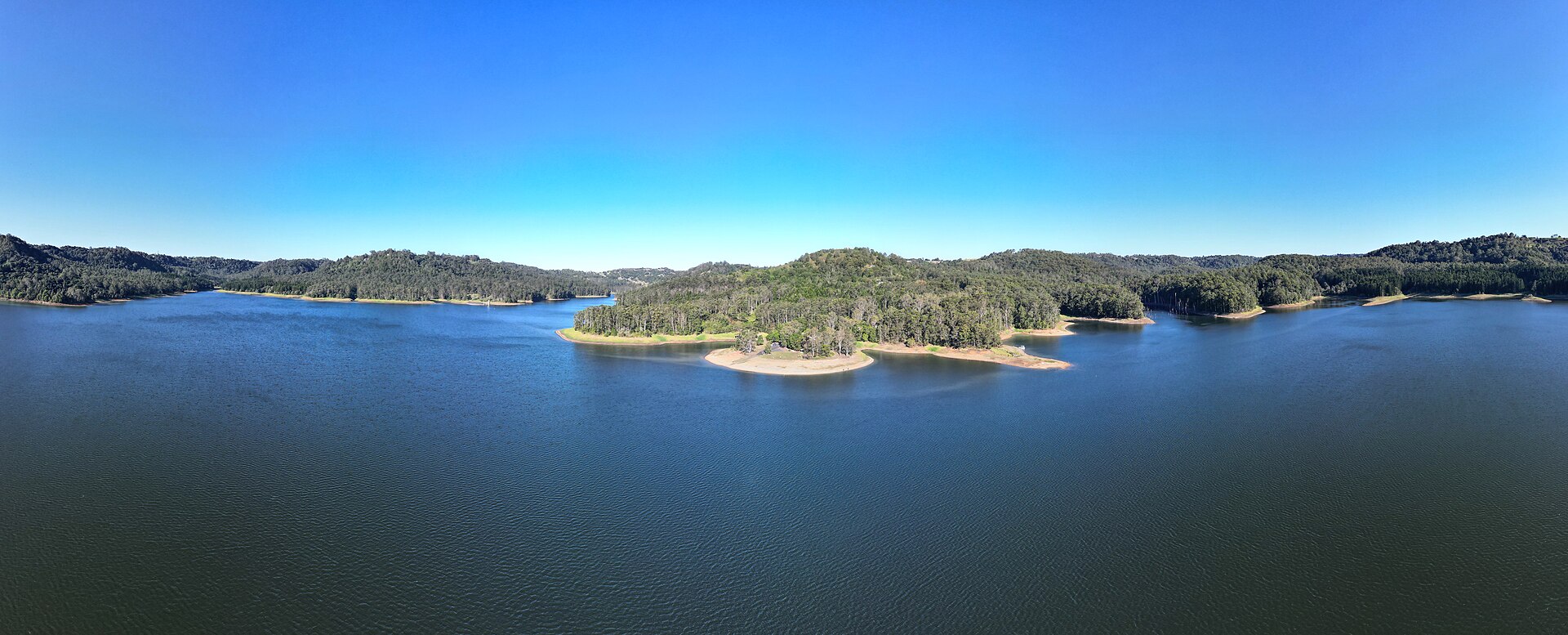 Aerial view of the blue water and forested shores of Lake Baroon
